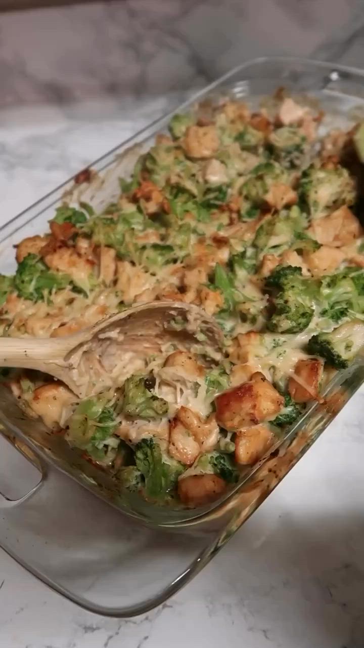 This may contain: a casserole dish with broccoli and chicken in it on a table