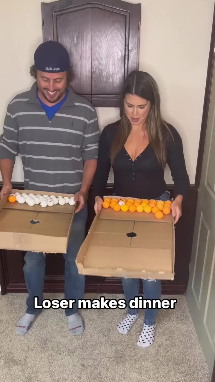 This may contain: a man and woman sitting on a bench with boxes of oranges in front of them