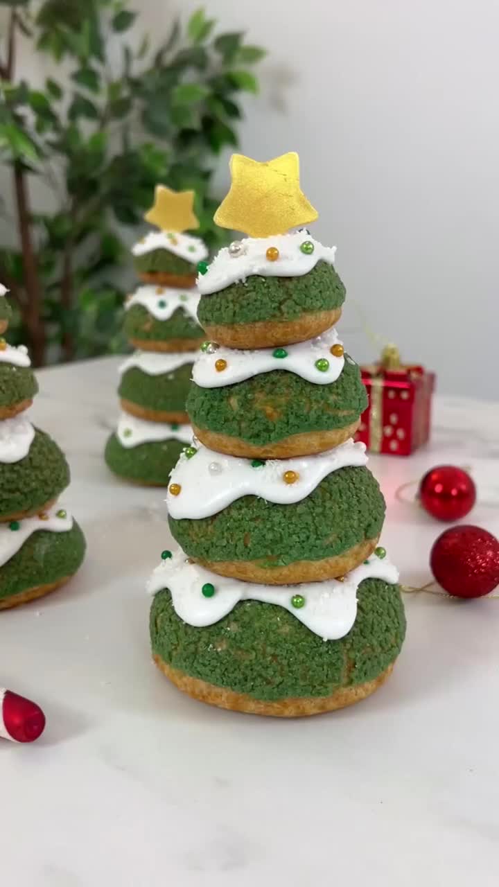 This may contain: green christmas cookies with white frosting and gold stars on top, sitting next to candy canes