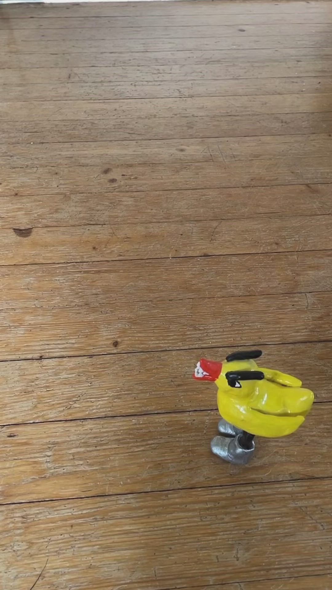 This may contain: a yellow toy boat sitting on top of a wooden floor