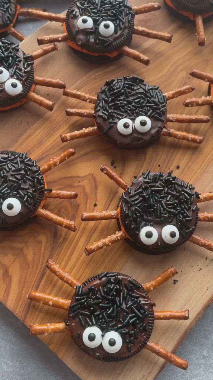 This may contain: spooky oreo spider halloween cookies on a wooden board