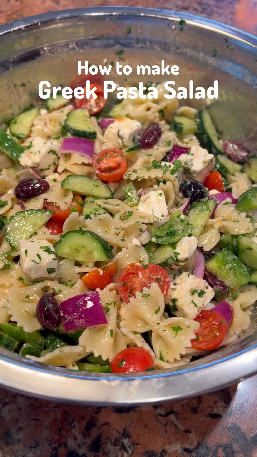 This may contain: a bowl filled with pasta salad on top of a table