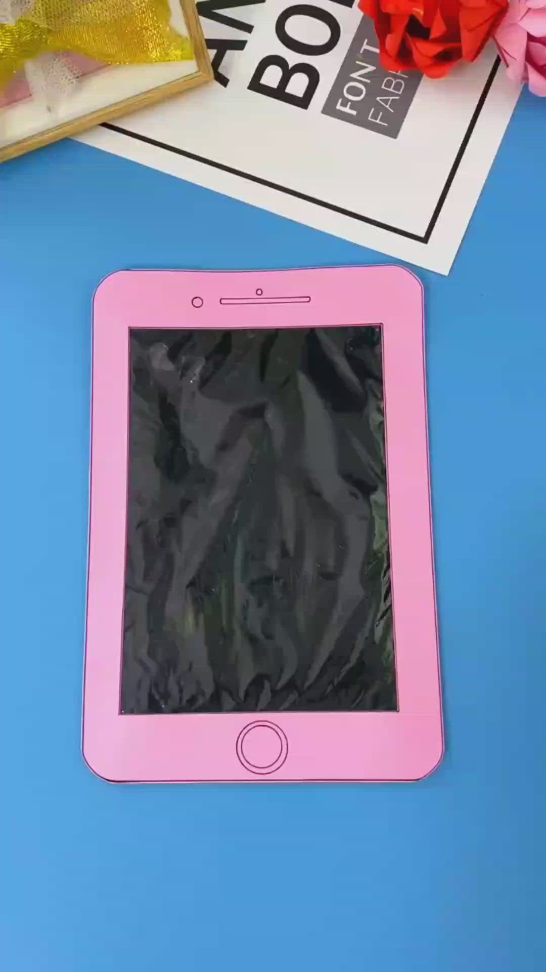 This may contain: a pink tablet sitting on top of a blue table