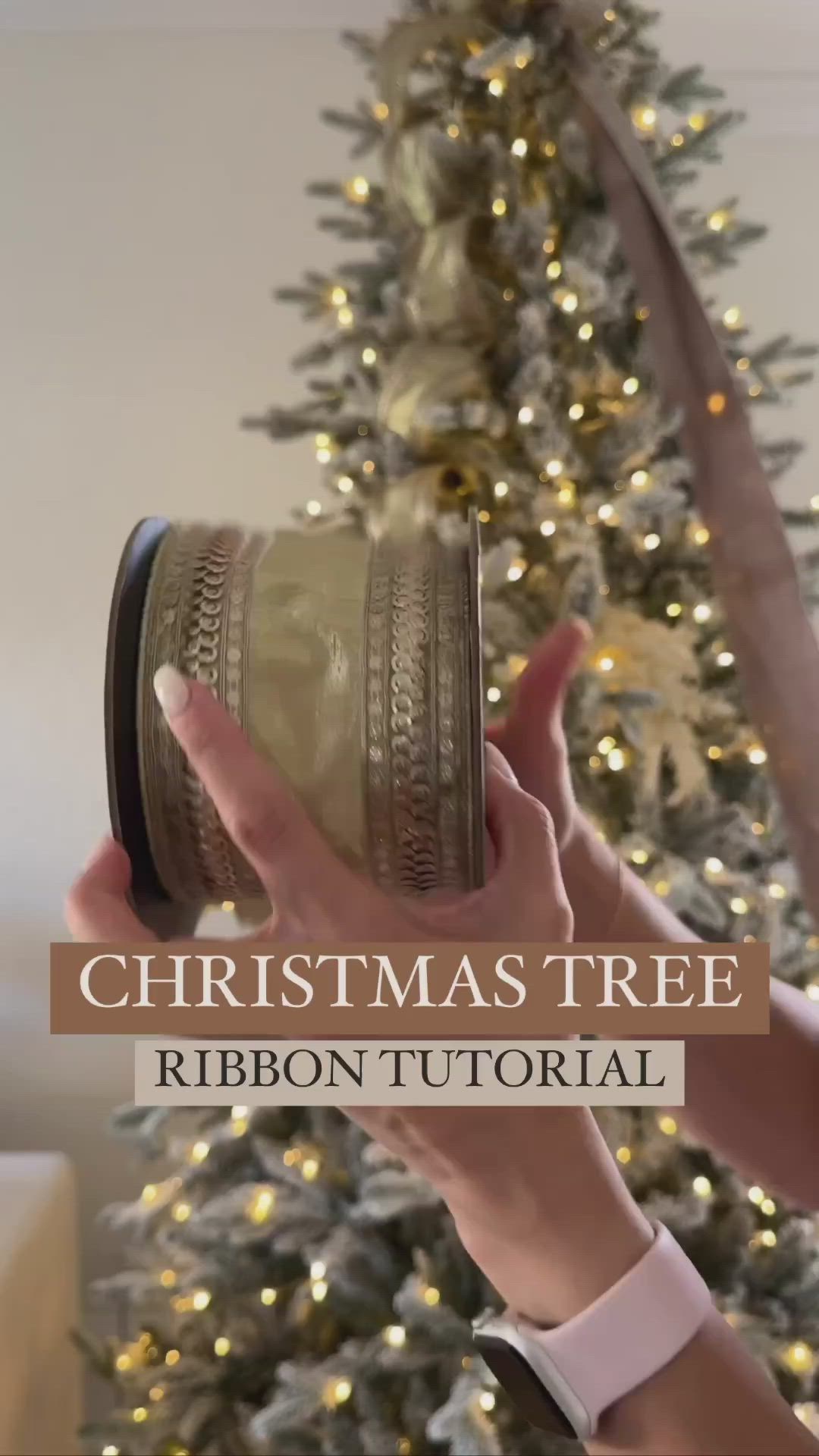 This may contain: a person holding a christmas tree ribbon in front of a christmas tree with lights on it