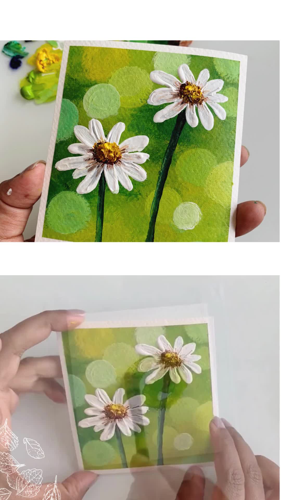 This may contain: someone is painting daisies on green paper