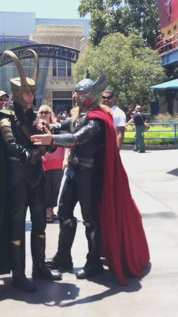 This may contain: a man dressed as thor from the avengers is standing in front of a group of people