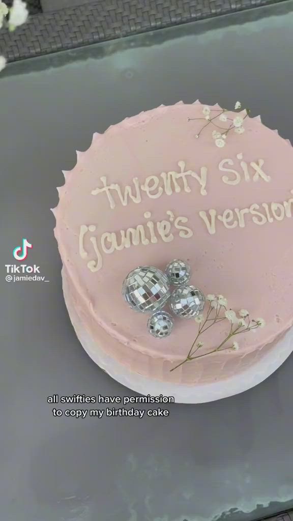 This may contain: there is a pink cake with white frosting on it that says twenty six giani's version