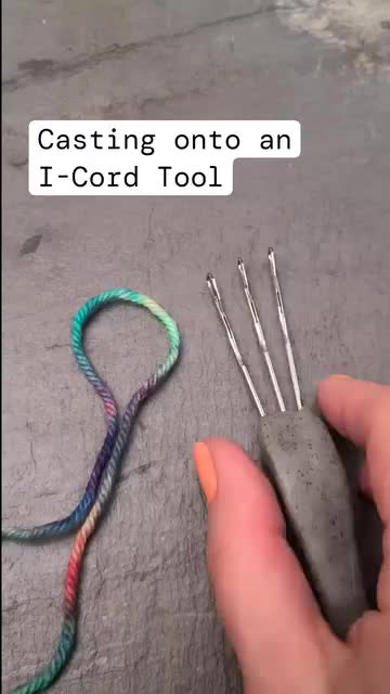 This may contain: someone is holding several needles with green and yellow yarn on them in front of the words, i - cord tool cast on