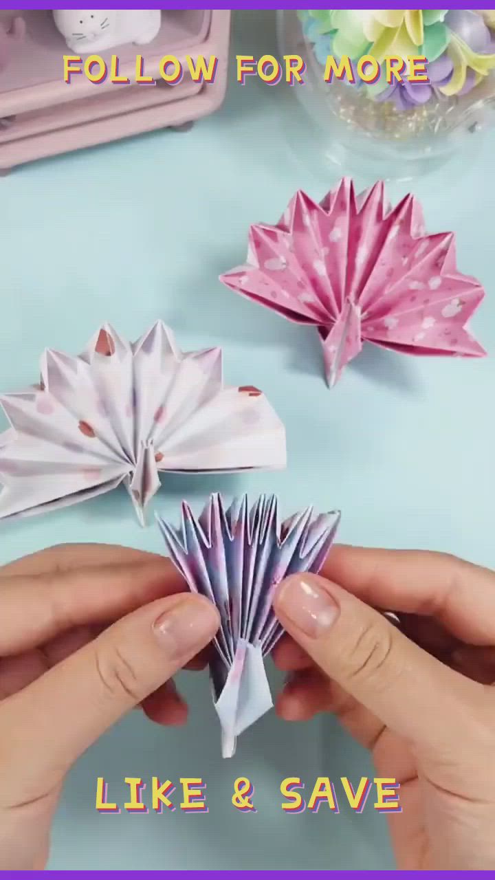 This may contain: two hands holding pink origami flowers with the words follow for more like & save