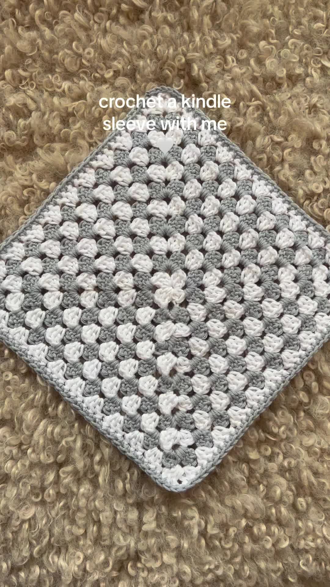 This may contain: a crocheted square is sitting on top of a brown carpet with white dots