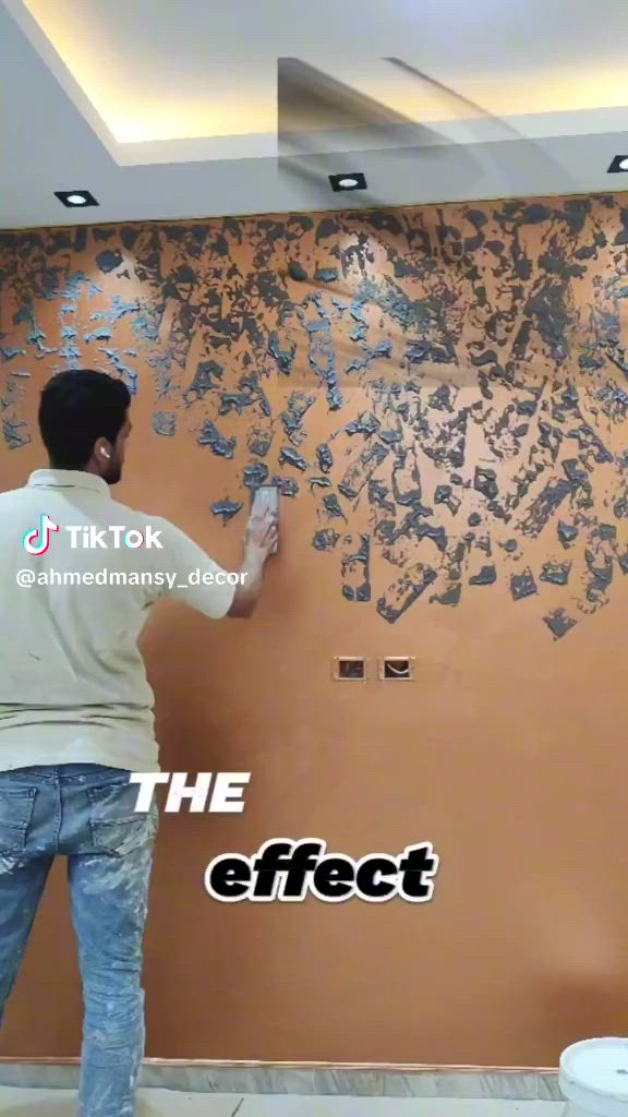 This may contain: a man is painting a wall with blue paint and the words the effect on it