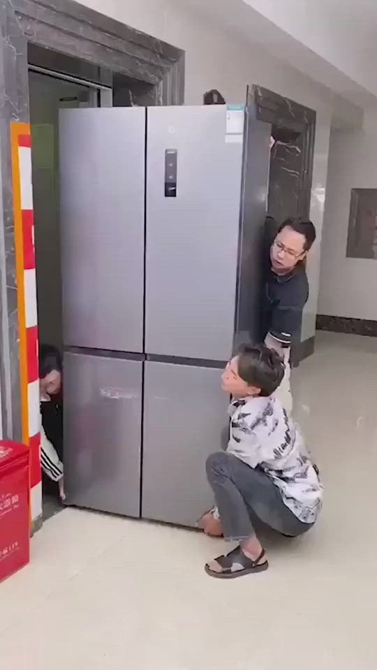 This may contain: two people standing in front of a refrigerator