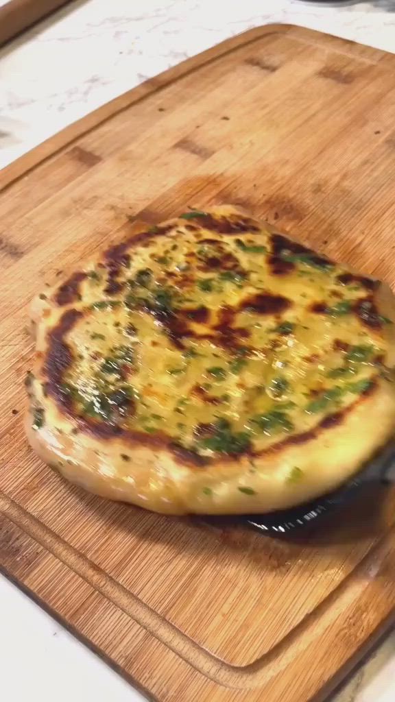 This may contain: a pizza sitting on top of a wooden cutting board