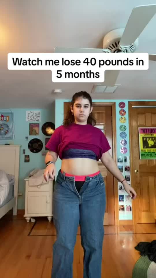 This may contain: a woman is standing in the middle of a room with her stomach exposed and there is a sign that says watch me lose 40 pounds in 5 months