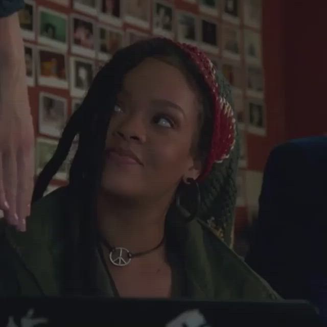 This may contain: a woman with dreadlocks sitting in front of a laptop computer