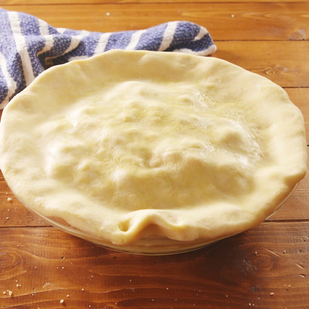 This may contain: a piece of chicken pot pie being held up by a fork with the rest of the casserole in it