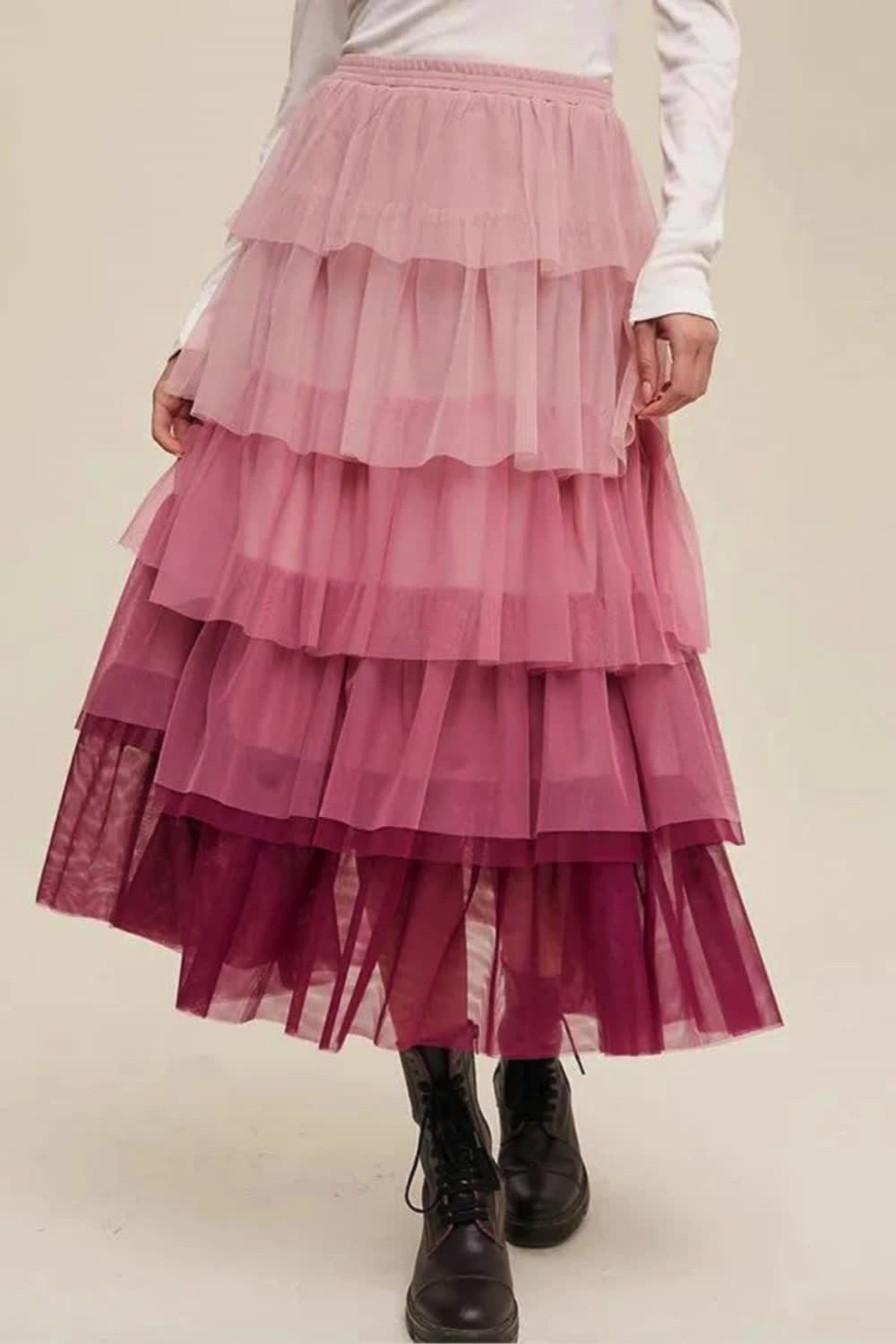 This Pink Gradient Mesh Ruffle Tiered Tulle Maxi Skirt features a stunning pink gradient, layered ruffles, and delicate tulle fabric. Its flowing, tiered design adds a touch of romantic elegance, perfect for special events or a stylish day out.