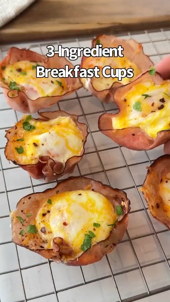 This may contain: there are eight baked potato cups on the rack with cheese and herbs in them, ready to be eaten