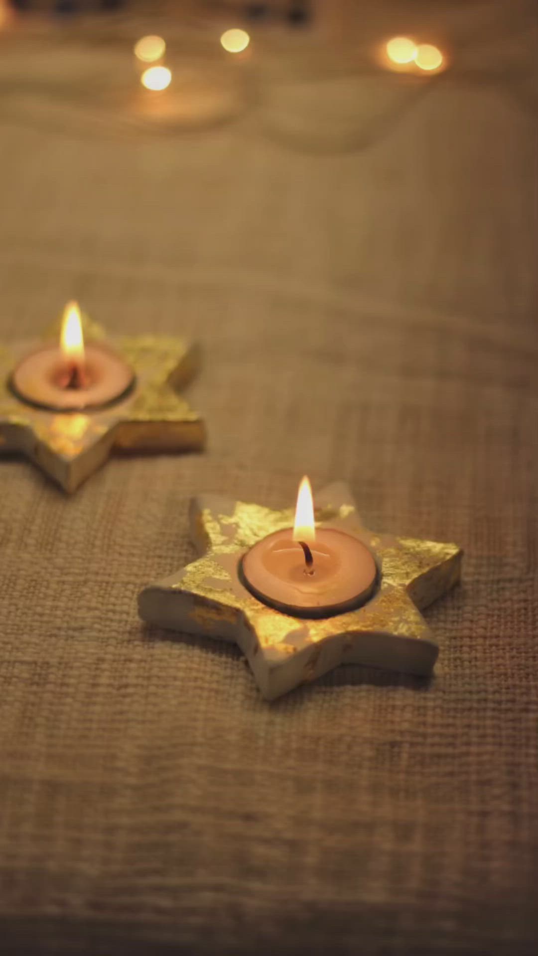 This may contain: two small candles sitting on top of a table next to each other in the shape of stars