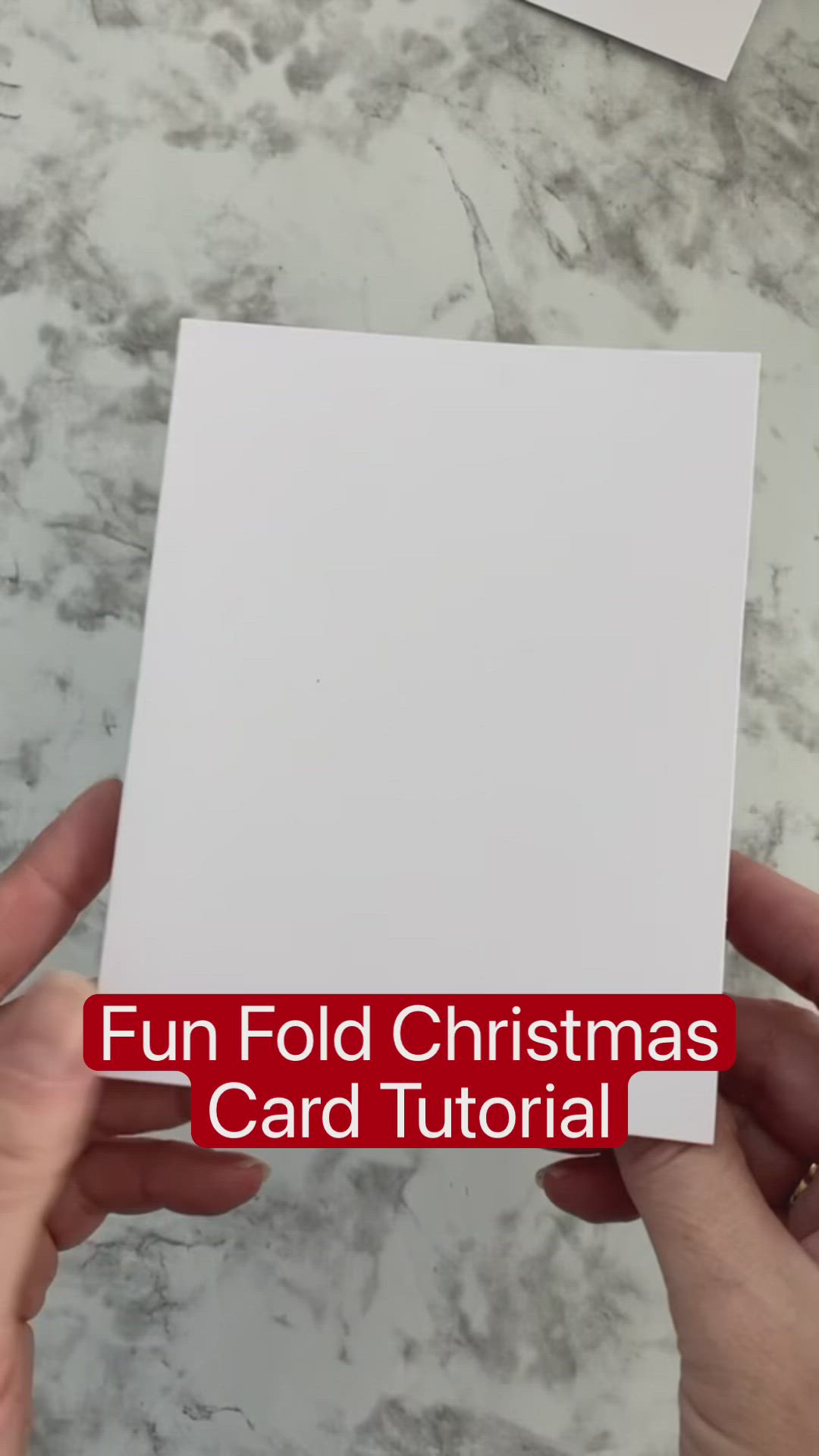 This may contain: someone holding up a white card with the words fun fold christmas card tutorial on it