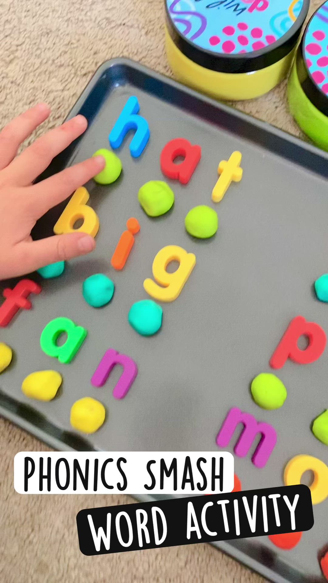 This may contain: a child's hand is touching the letters on a tray with plastic magnets