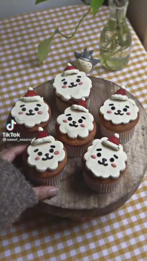 This may contain: cupcakes with frosting are on a wooden platter