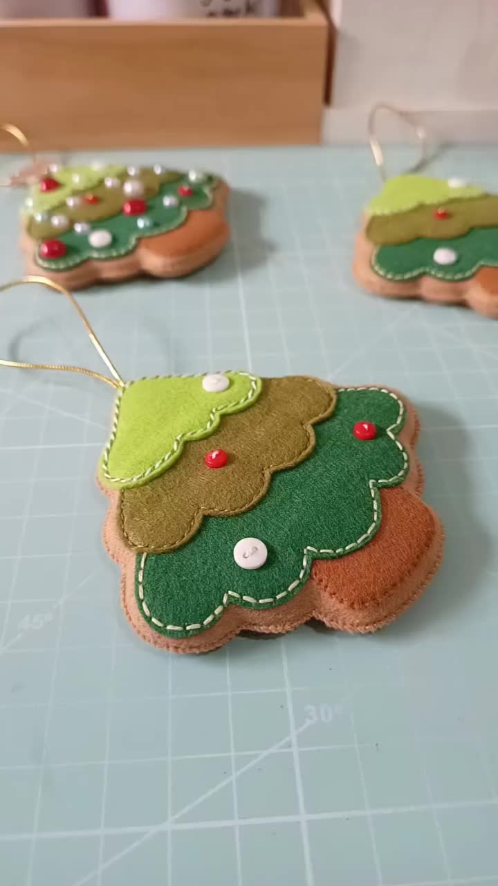 This may contain: christmas cookies decorated with santa clause and tree decorations on a cutting board next to cinnamon sticks