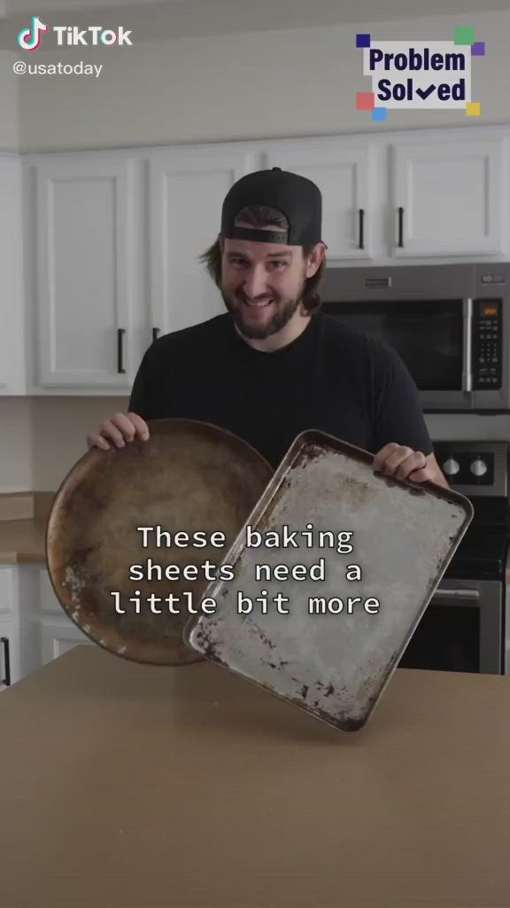 This may contain: a man holding a baking pan with the words, these baking sheets need a little bit more