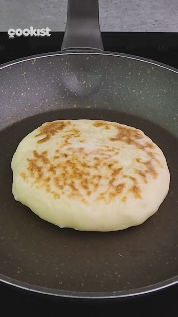 This may contain: some food is cooking in a pan on top of the stove and it looks like pancakes