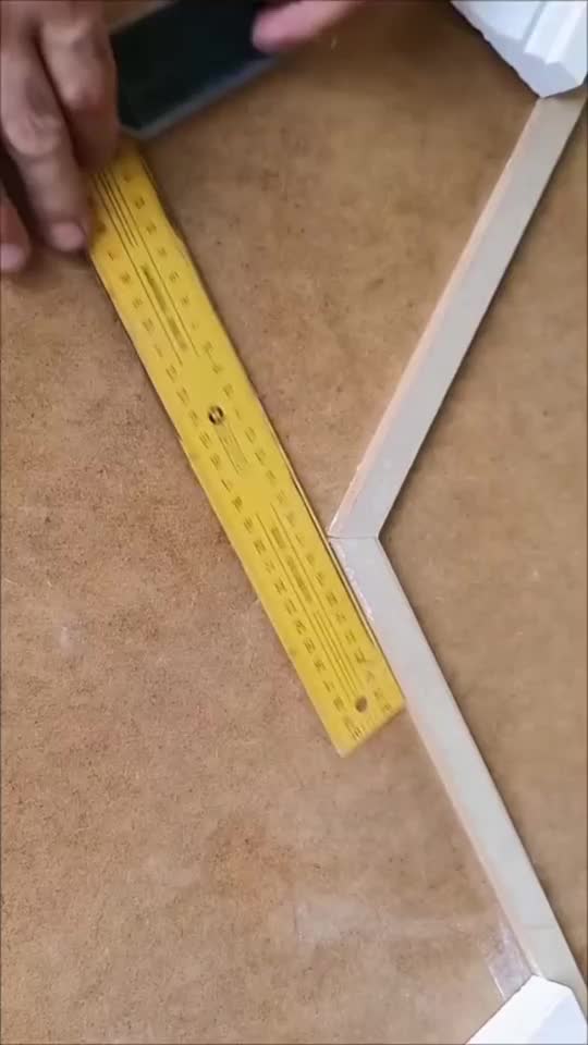 This may contain: a person measuring the width of a piece of cardboard