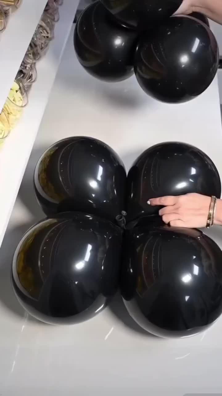 This may contain: a birthday cake made out of black and silver balloons with the number 3 on top