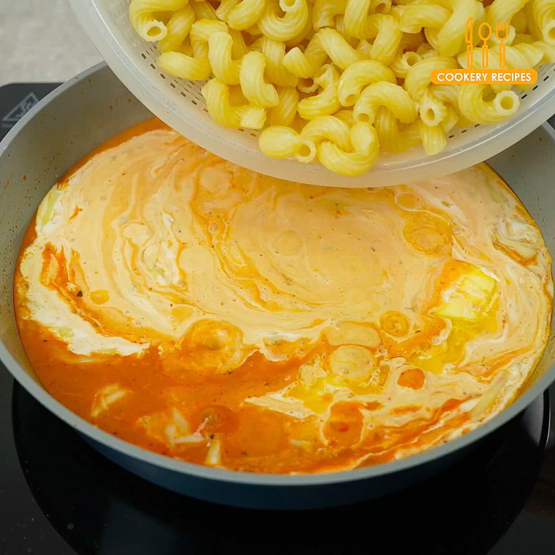 This may contain: macaroni and cheese being cooked in a pot on top of the stovetop