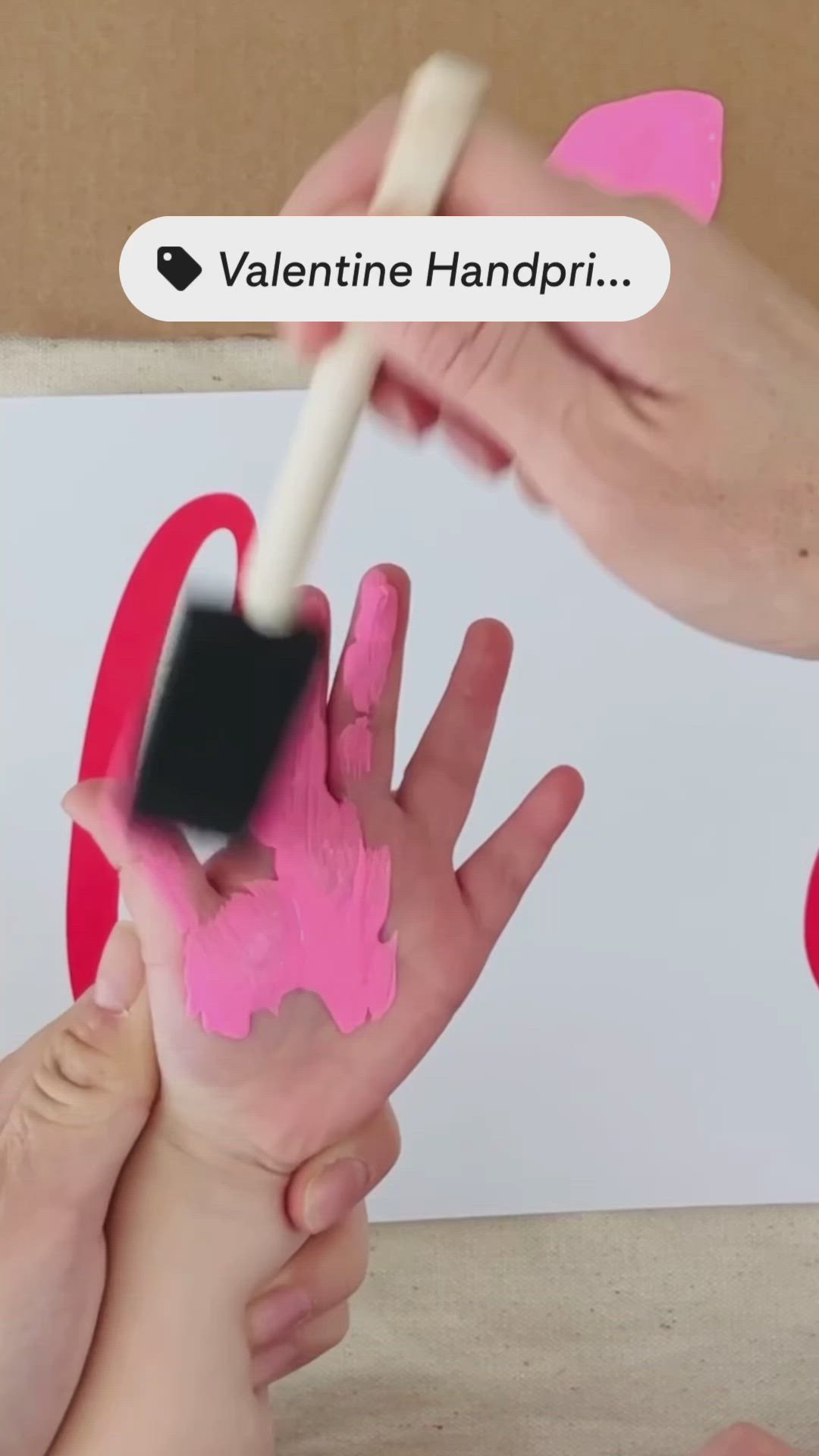 This may contain: two hands are being painted with pink paint