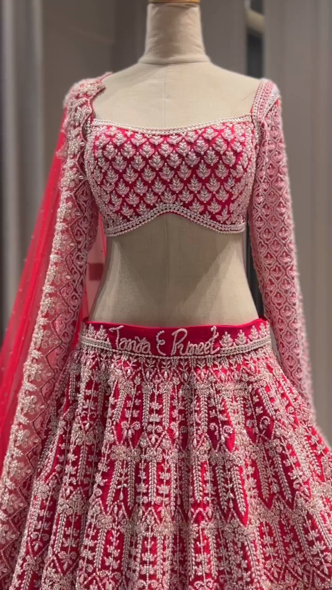 This may contain: a red and white wedding dress on display in a store window, with the top half covered