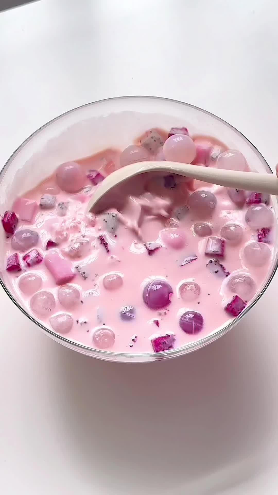 This contains: A beautifully garnished glass of Dragon Fruit Cocktail, with a vibrant pink hue, fresh dragon fruit slices, and a colorful umbrella.