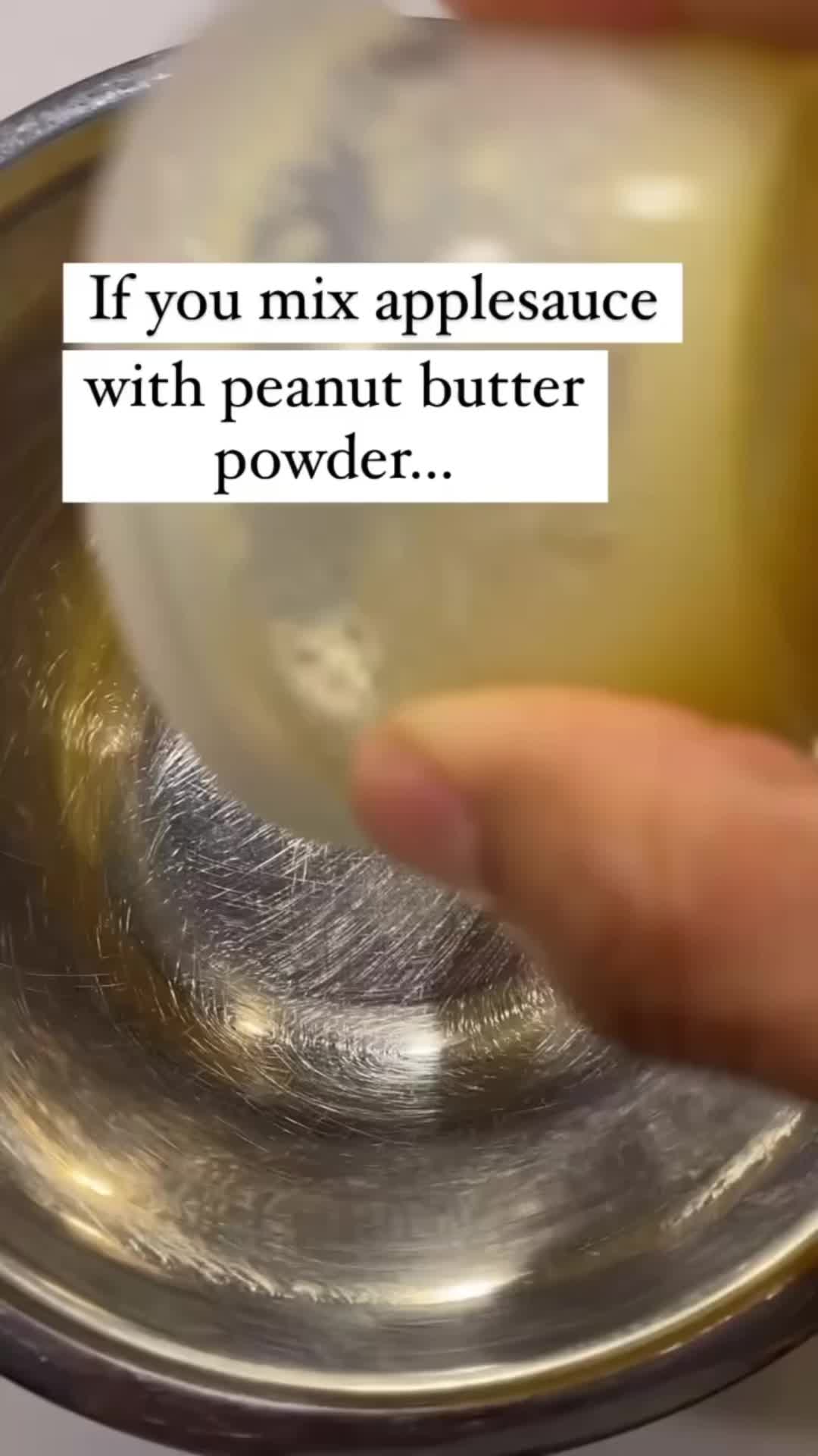 This may contain: a person holding a piece of butter over a metal bowl with the words if you mix applesauce with peanut butter powder