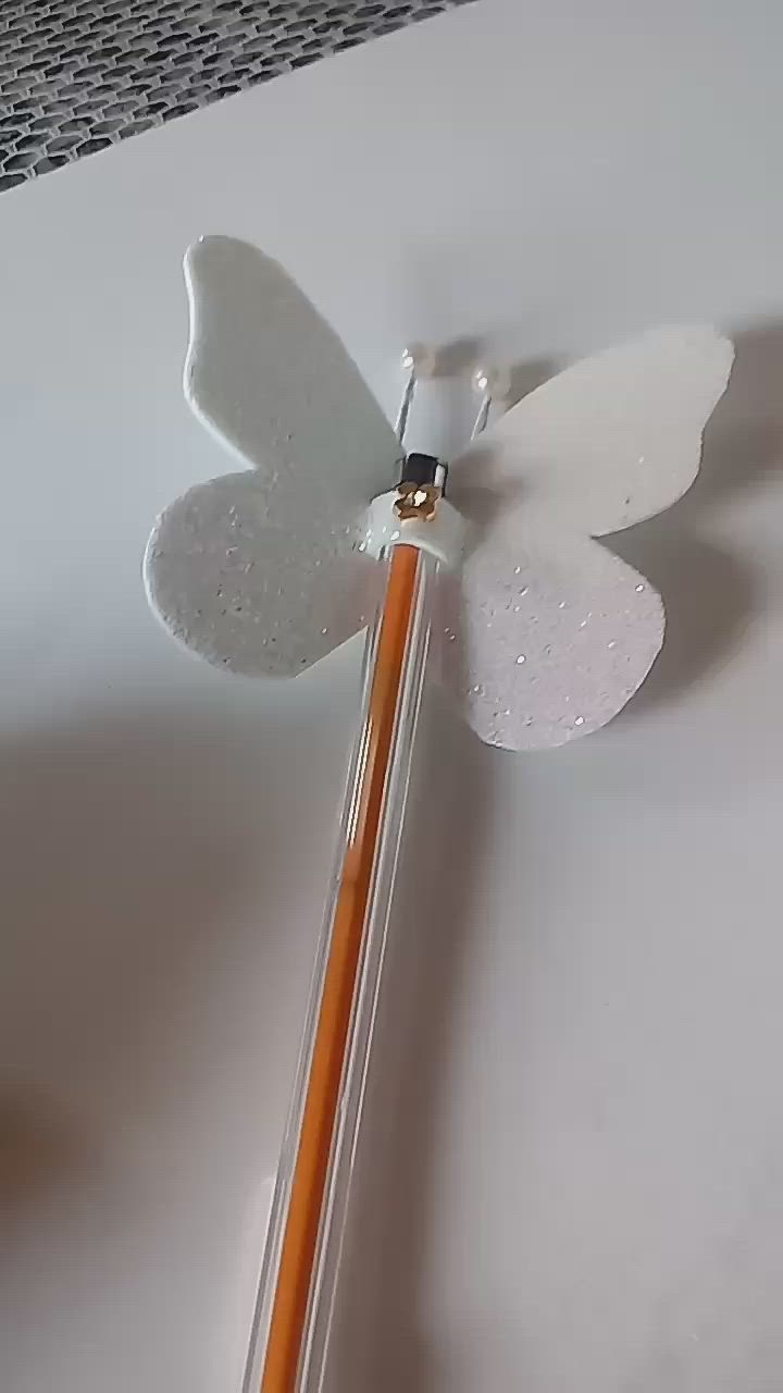 This may contain: a white butterfly shaped object sitting on top of a table next to a pencil and eraser