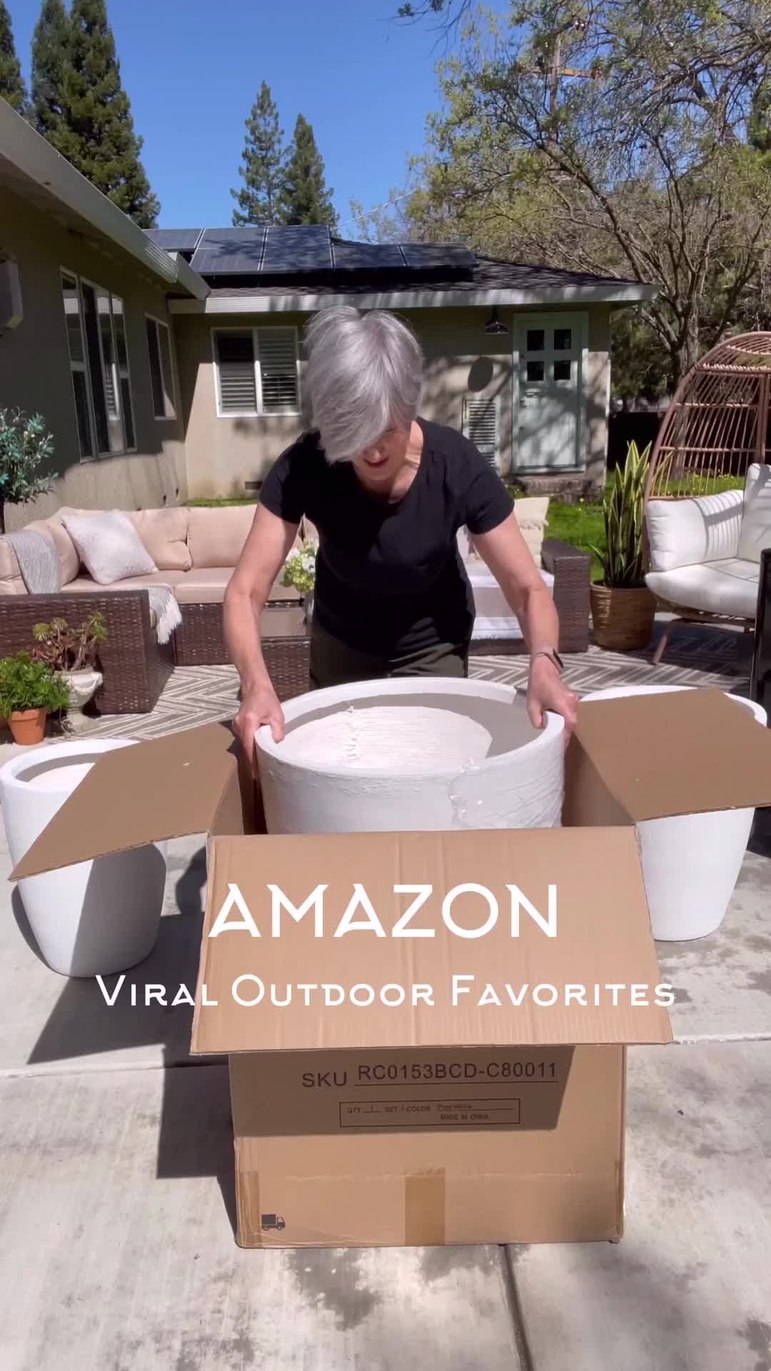 This may contain: an older woman is placing flowers in a large potted planter on the patio