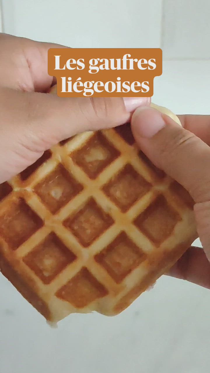 This may contain: a person holding a waffle with the words les gaufres ligeoises on it