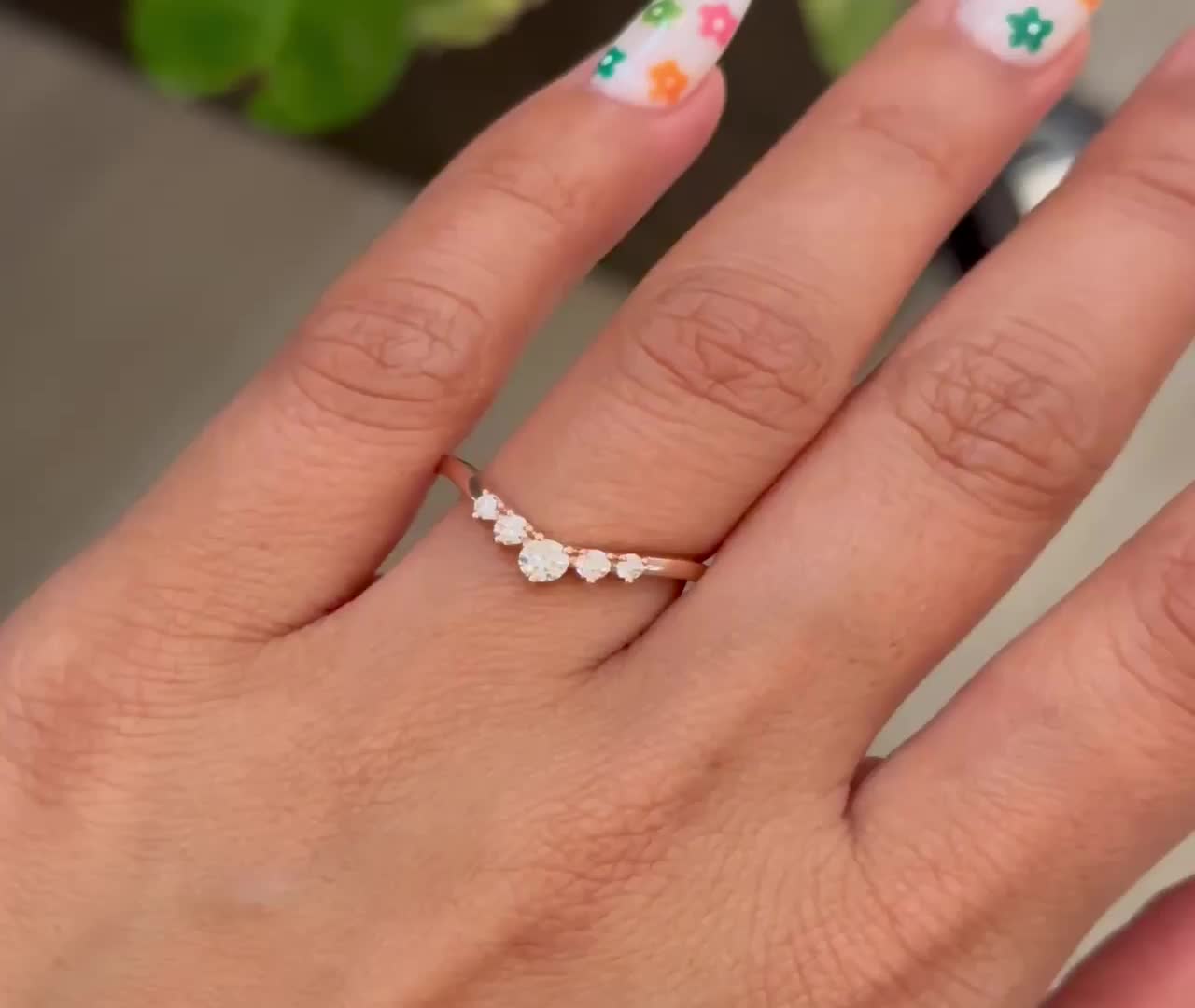 This may contain: a woman's hand with flowers painted on it and a ring in the middle