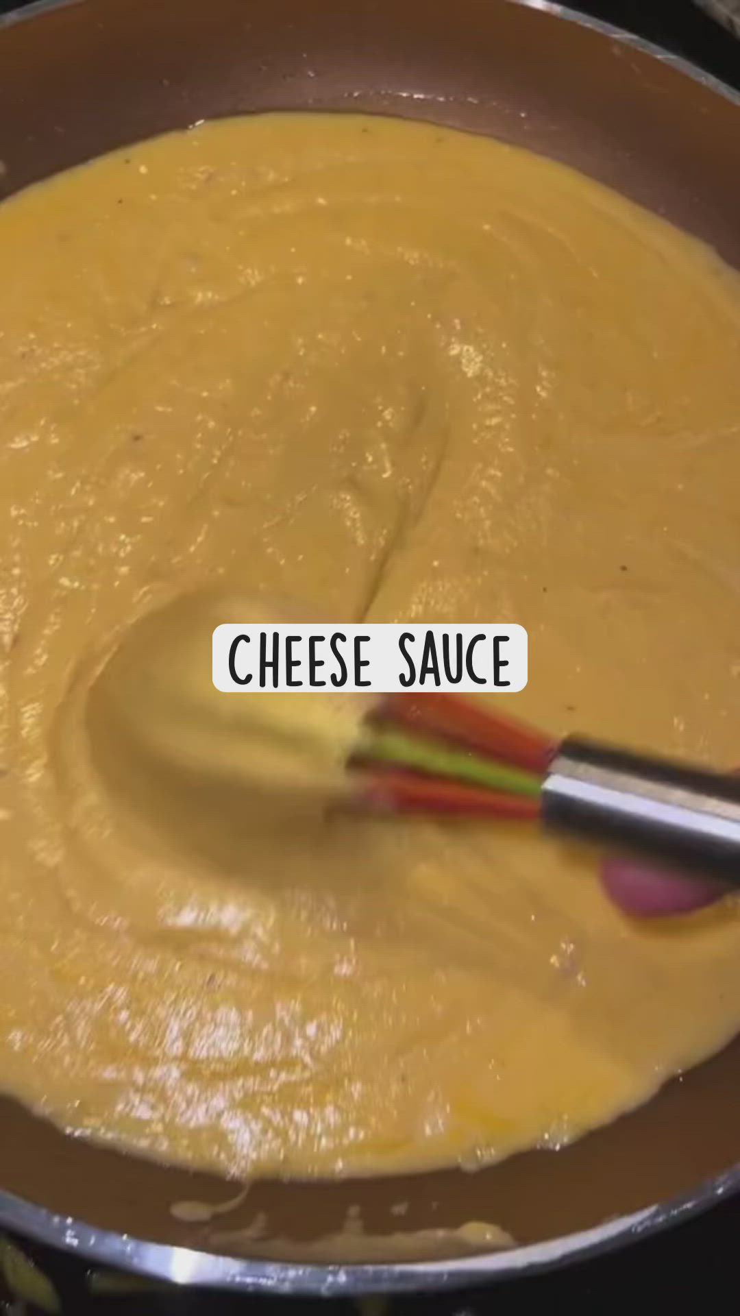 This may contain: a spoon mixing cheese sauce in a pan with the words cheese sauce written on it