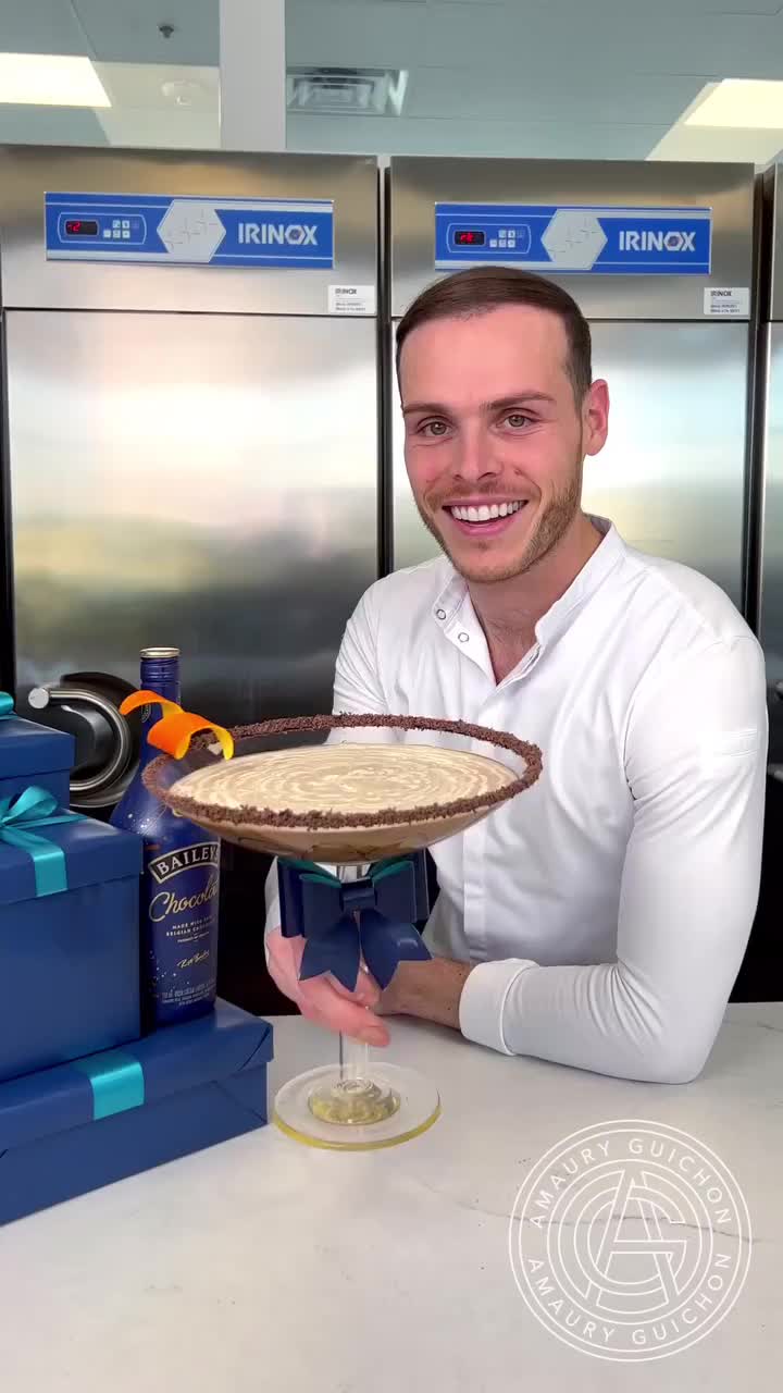 This may contain: a man sitting at a table with a pie in front of him and some blue boxes behind him