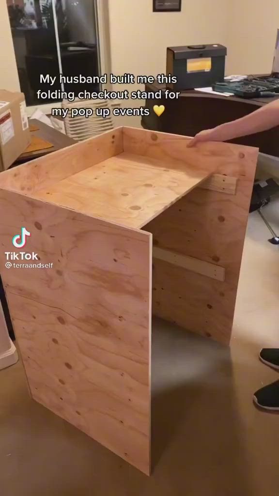 This may contain: a wooden box sitting on top of a hard wood floor next to a computer desk