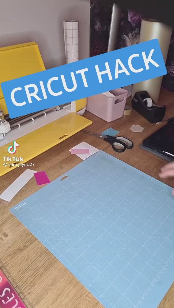 This may contain: a person cutting paper on top of a wooden table with a blue sign over it that says cricut hack