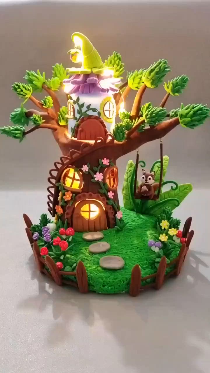 This may contain: an illuminated tree house is in the shape of a fairy land with mushrooms and trees