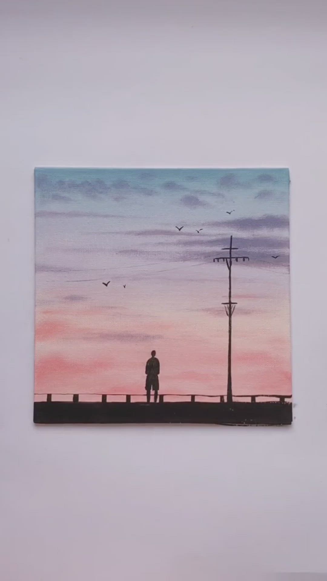 This may contain: a man standing on top of a bridge under a pink sky