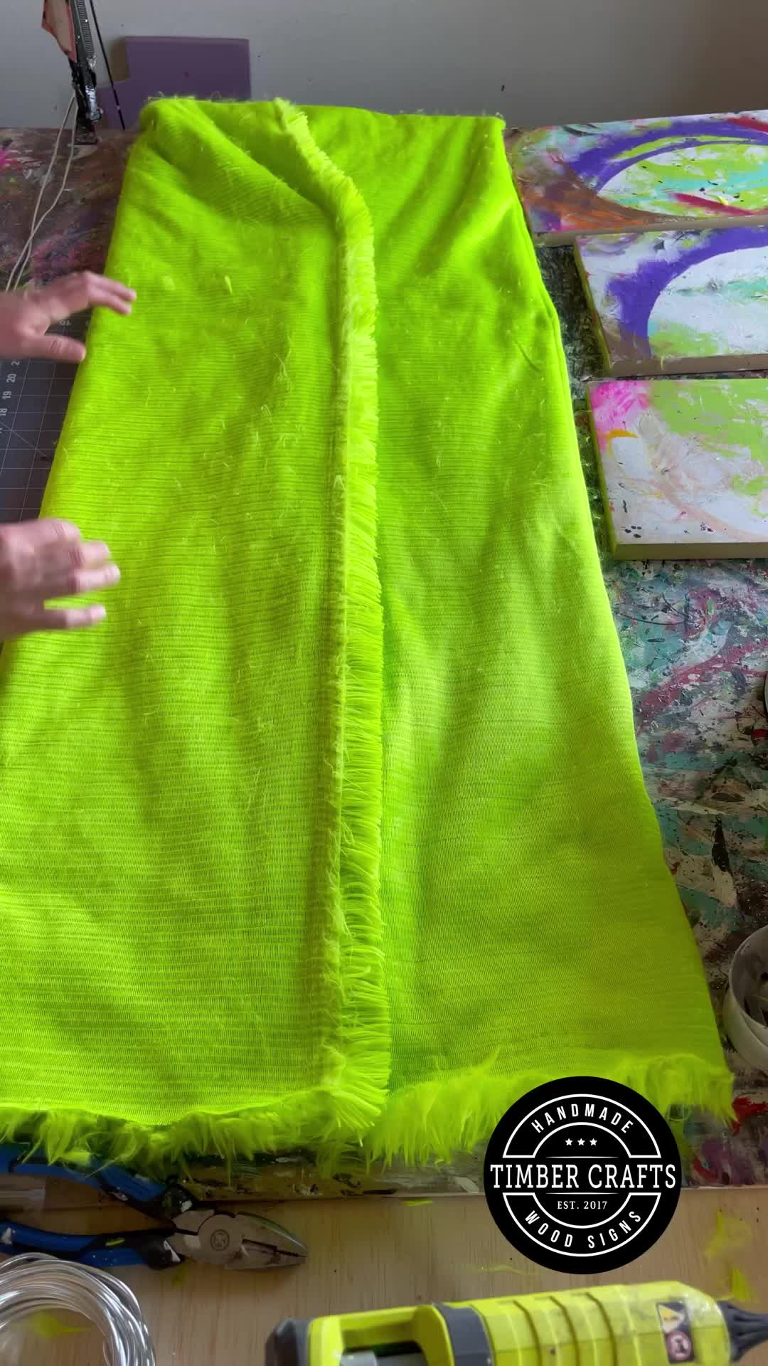 This may contain: someone is using a sewing machine to sew something on a piece of cloth that has been dyed neon green