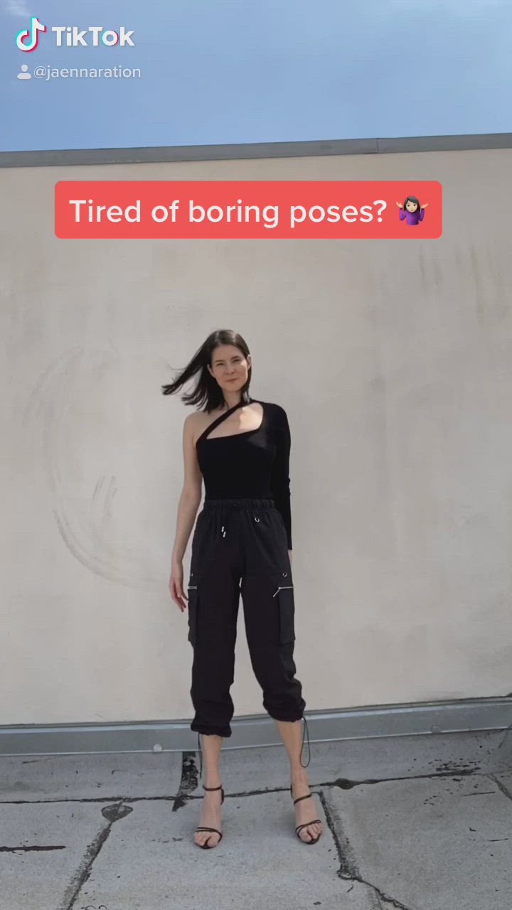 This may contain: a woman standing in front of a wall with the caption tired of boring poses?