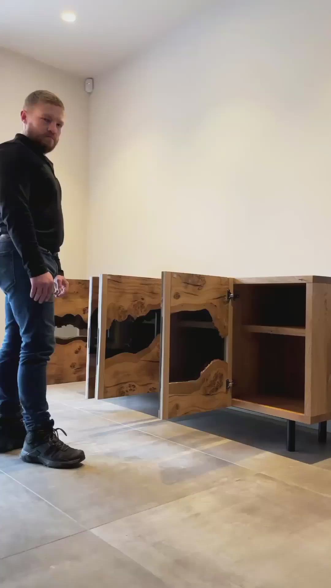 This may contain: a man is standing in front of some wooden cabinets and looking at the flooring