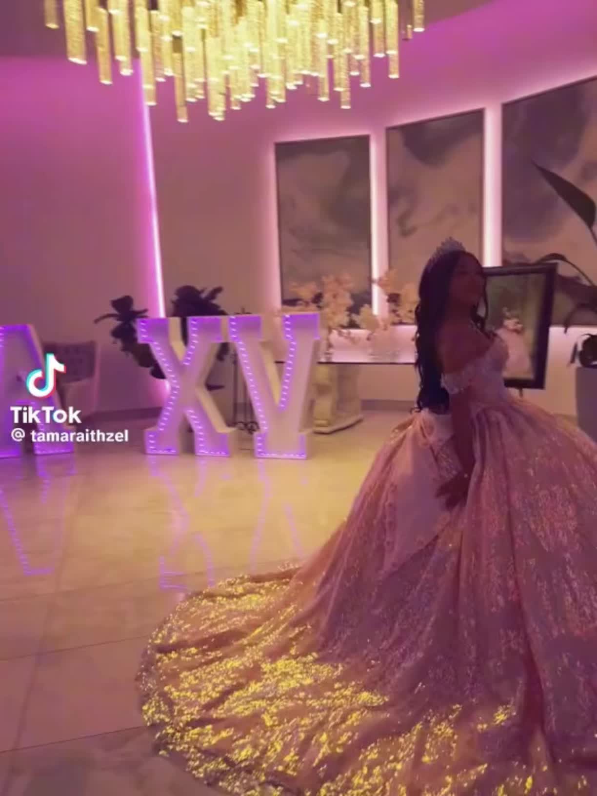 This may contain: a woman in a pink and gold dress standing on a dancefloored floor